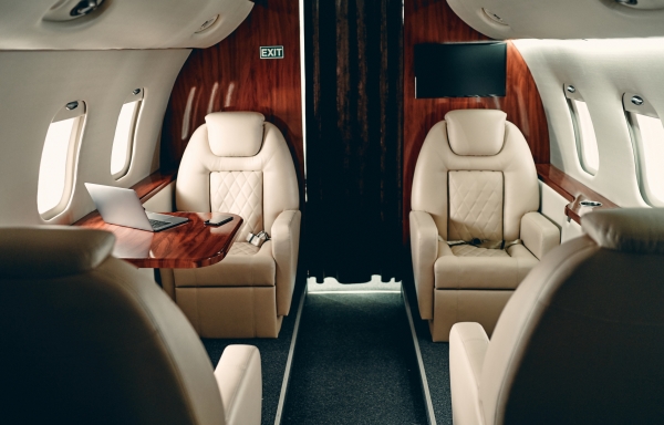 Cabin of luxury private jet. Empty aircraft with white leather chairs.